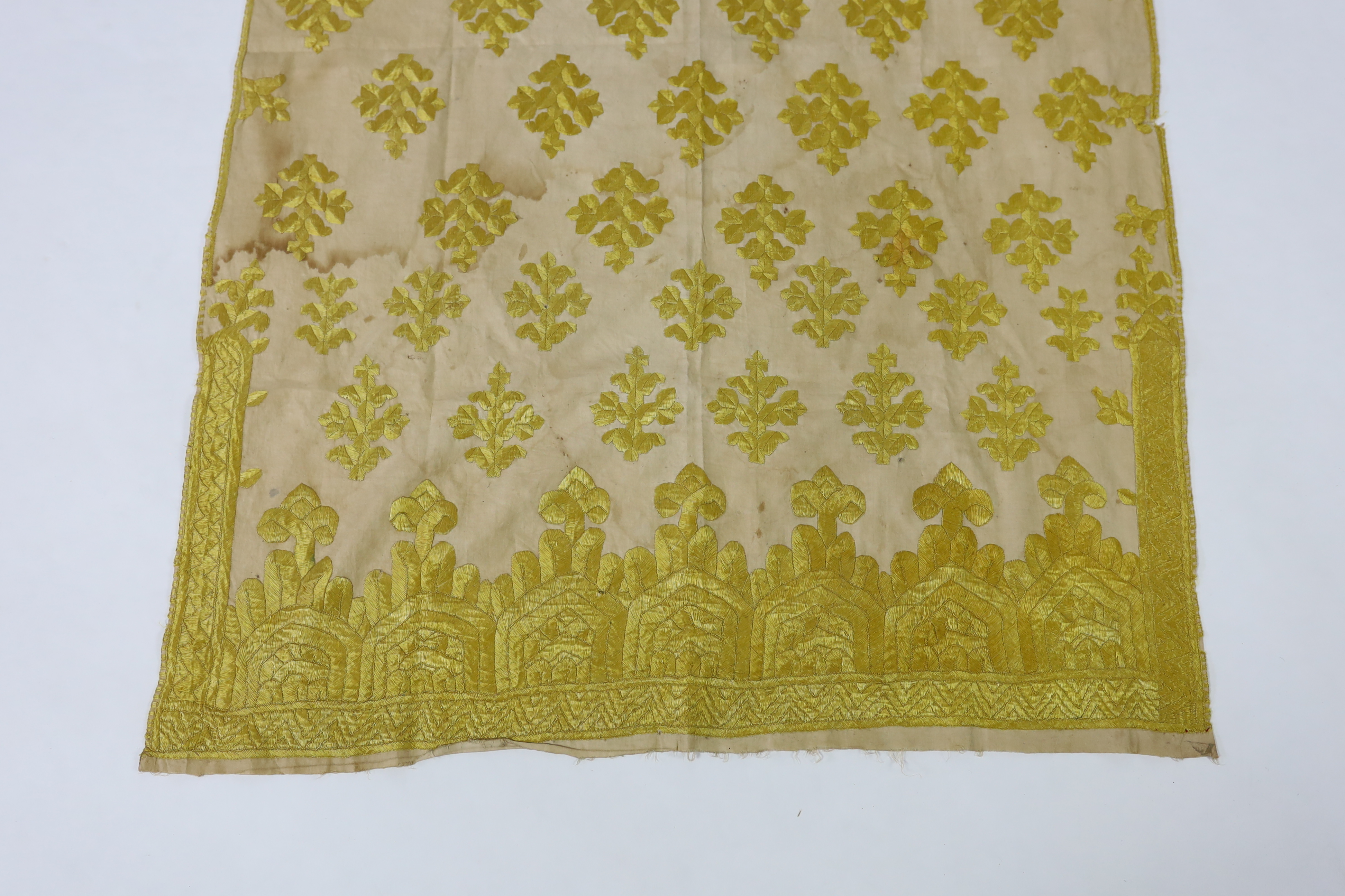 An early 20th century North Indian cotton yellow silk hand embroidered panel, with wide embroidered borders and all over stylistic spot motifs, 122 cm long x 80cm wide